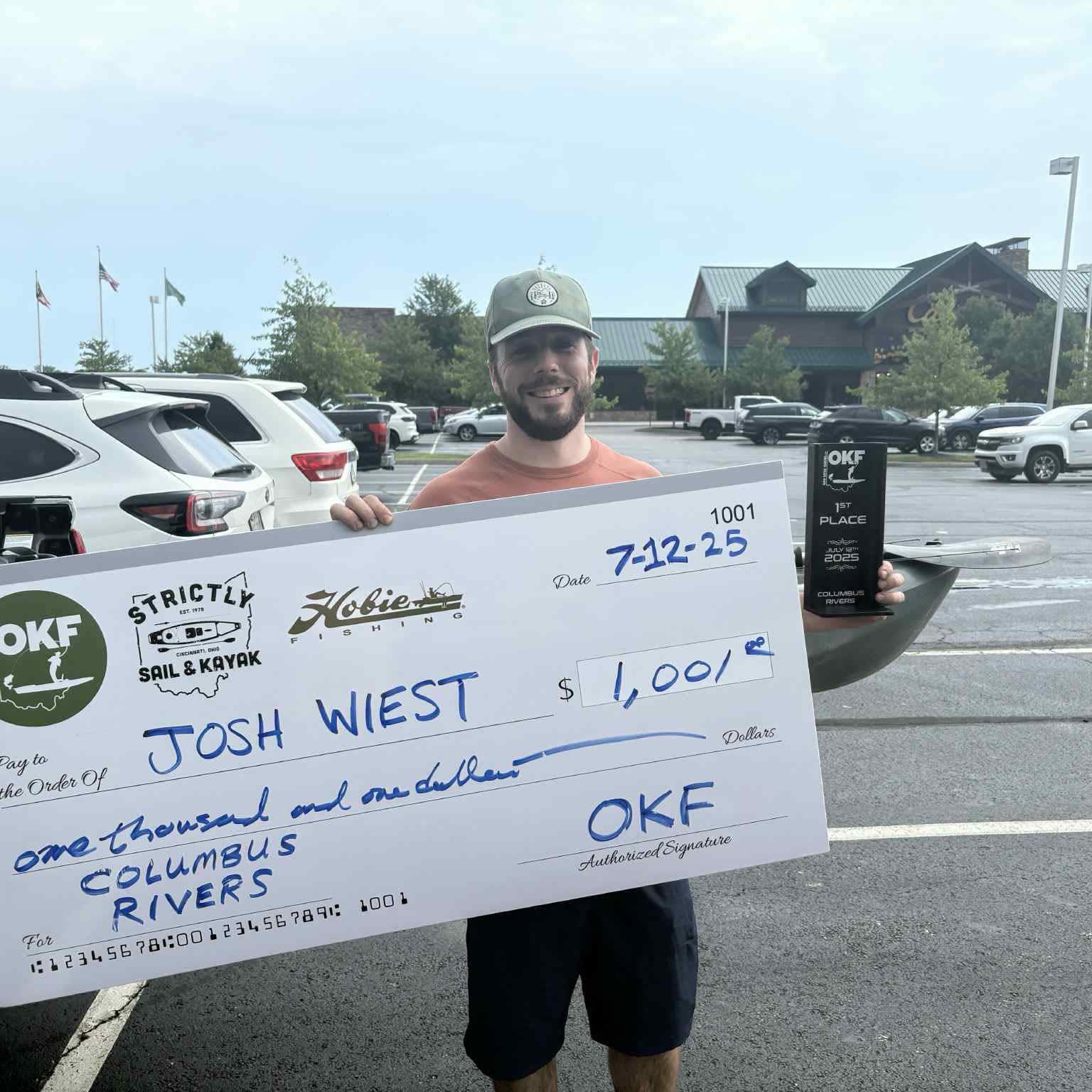 OKF angler holding a trophy and award check from the July 2025 Columbus Rivers event